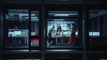 Shot from Outside the Window: Businessmen and Businesswomen Working in the Office. Managers and...