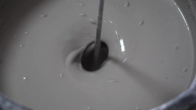 Self-leveling floor. Preparation of a liquid self-leveling floor solution in a barrel. 