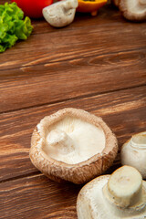 side view of fresh mushrooms on rustic wooden background with copy space