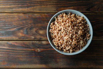 Bowl of tasty buckwheat on wooden table