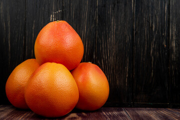 side view of fresh ripe grapefruits isolated on dark wooden background with copy space