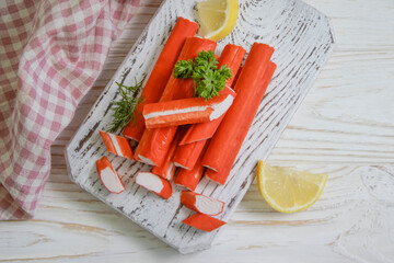 crab sticks, parsley on a wooden background
