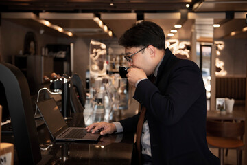 Businessman relax by drinking coffee while working in a coffee shop