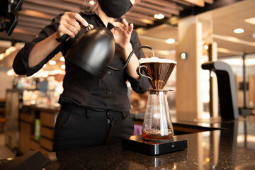 Fototapeta na wymiar Barista's hand making pouring hot water to coffee drip bag