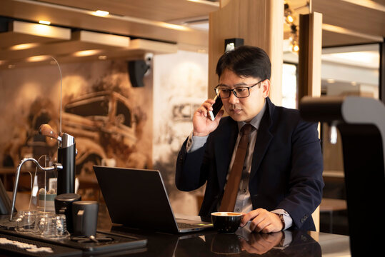 Businessman discussion financial with his team via mobile phone in the cafe