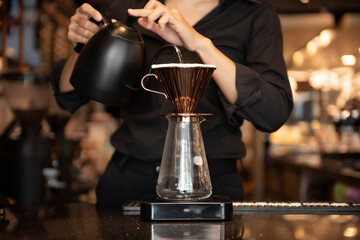 Fototapeta na wymiar Barista's hand making pouring hot water to coffee drip bag