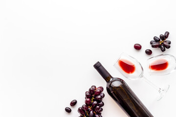 Two glasses of red wine with bottle and grape