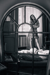 Young, slender girl reflected in an old mirror
