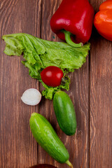 side view of fresh vegetables colorful bell peppers tomato cucumber and radish on wooden rustic background