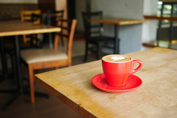 a cup of late coffee with flower shape design on top at cafe 