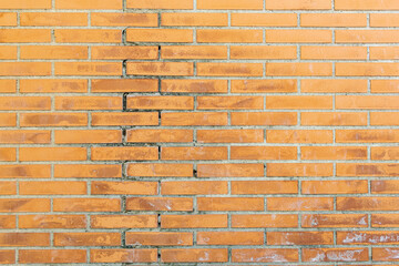 orange brick wall with dampness and damage to the cement.Texture pattern.