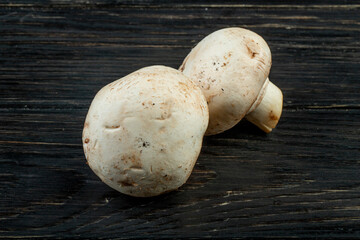 side view of fresh white mushrooms isolated on dark wooden background