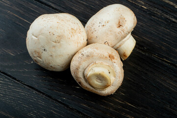 side view of fresh white mushrooms isolated on dark wooden background