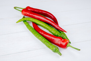 side view of green and red hot chili peppers isolated on white background