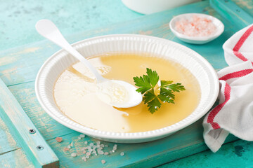 Chicken broth from organic farm poultry in white bowl, selective focus