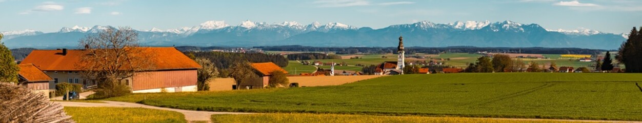 High resolution stitched panorama of a beautiful spring view on a sunny day with a church and the alps in the background near Schnaitsee, Bavaria, Germany