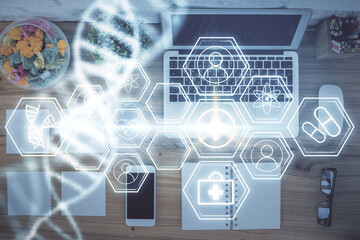 DNA hologram drawings over computer on the desktop background. Top view. Multi exposure. Concept medical education.
