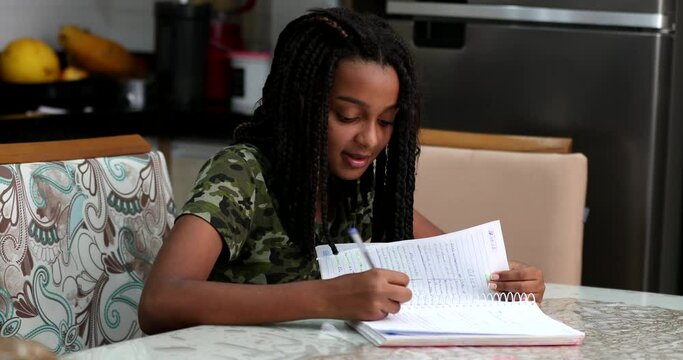 Teen girl doing homework at home, concentrated child studying - Powered by Adobe