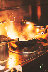 中華料理で鍋を振る料理人