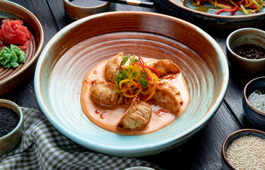 side view of traditional asian dumplings with meat and vegetables served with sauce on a plate on...