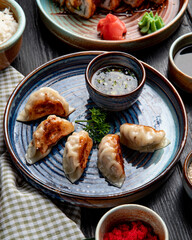 side view of traditional asian dumplings with meat and vegetables served with soy sauce on a plate...