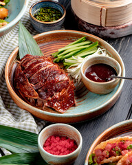 zijaanzicht van traditioneel Aziatisch eten pekingeend met komkommers en saus op een bord