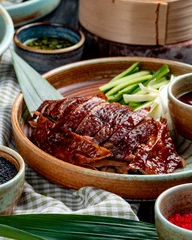 Acrylic prints Beijing side view of traditional asian food peking duck with cucumbers and sauce on a plate
