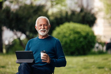Fototapeta premium Senior man, enjoying his free time, while using a tablet.