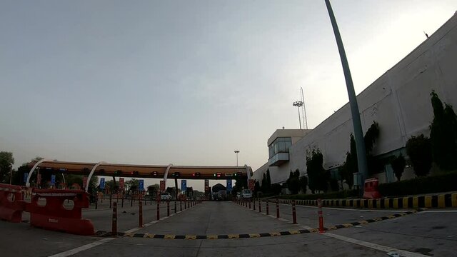 The car is at a toll Plaza situated at the midway. Time-lapse shooting with a camera that is mounted on the bonnet of the car.