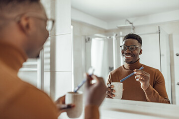 Adult African man, making sure he has a fresh breath.