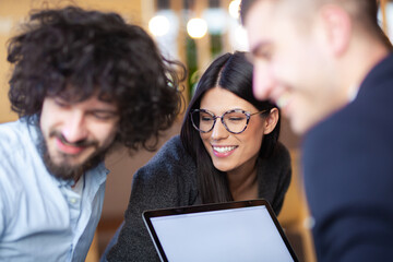 Young successful business people having a creative meeting at a cafe. Smiling and happy face expressions.