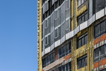 A high-rise building is under construction. metal and concrete structures. A sunny summer day.