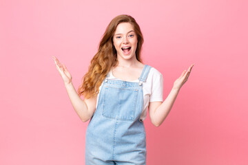 red head pretty woman feeling happy and astonished at something unbelievable