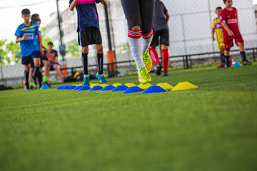 Obraz na płótnie Canvas Soccer ball tactics on grass field with barrier for training children jump skill