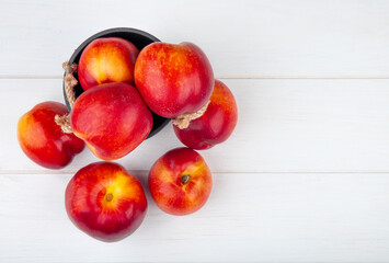 top view of fresh ripe nectarines in a small bucket on white background with copy space