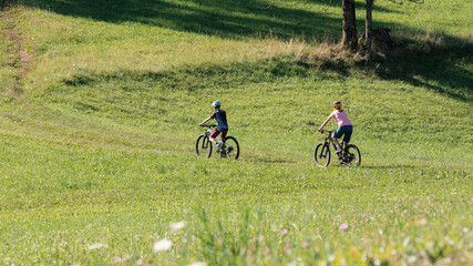 Two girls on mtb bikes. Mother and daughter riding on a trail.