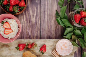 top view of fresh ripe strawberries  cottage cheese and croissants on rustic wooden background with copy space