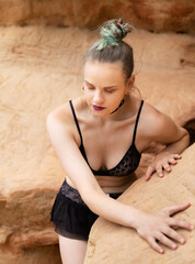 Young woman in black lingerie in a cave