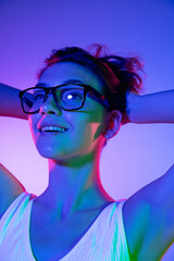 Young woman's portrait on gradient colors studio background in neon. Concept of human emotions.