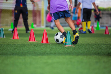 Children playing control soccer ball tactics on grass field with for training