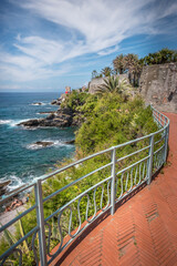 Obraz premium View of the beautiful promenade of Nervi in Genoa, with palm trees and bricks, Italy.