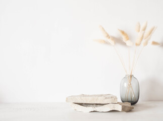 Grey natural stones podium on white background, platform for product display and dry branches in...