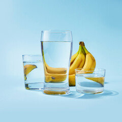 Bunch of bananas on a colored background. Bananas on a blue background with glasses. Reflection of bananas in a glasses