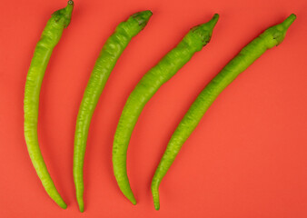 top view of green chili peppers isolated on red background