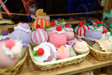Fototapeta na wymiar Knitted cupcakes of different colors on a store shelf