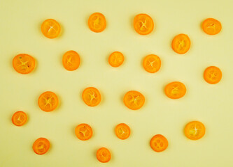 top view of kumquat fruit slices isolated on light yellow color background