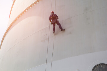 Male worker rope access  inspection of thickness storage tank
