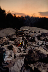 Fire making process in the wild at sunset. Building of campfire using dry branches in forest