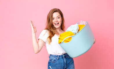 red head pretty woman feeling happy and astonished at something unbelievable and holding a wash...