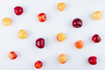 Naklejka na ściany i meble top view of ripe red and yellow cherries isolated on white background
